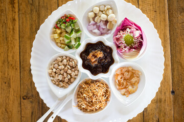 Miang Kham is a traditional Thai dessert. It is currently sold as street food. It involves wrapping several delicacy in lotus-petal leaves along with sweet, salty and spicy sauces.