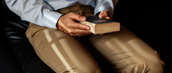Christian man is sitting and opening a Bible. In order to pray before Jesus remember His goodness. Concept wish faith reading.