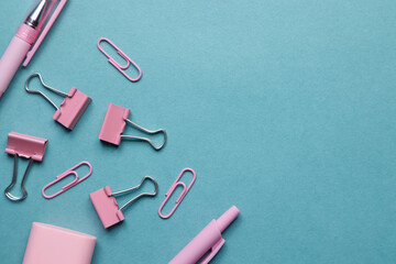 Flatley on a school theme with pencils and pens, paper clips and stickers. Flat layout with a blank blue background.