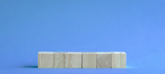 6 letter blank and wood blocks on table with blue background.