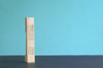 6 letter blank and wood block stacked up, blue background. Copy space.
