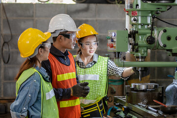 Asian Group industrial manager man demonstration and training mechanic worker woman  operating industrial lathe machine. Industry and engineering people technology concept .