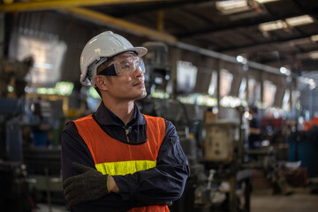 A asian male construction engineer at construction site. man of skillful factory workers using machine equipment in workshop.