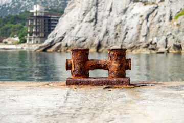 Fototapeta premium Knechts on pier against backdrop of sea and mountains and Abandoned hotel.
