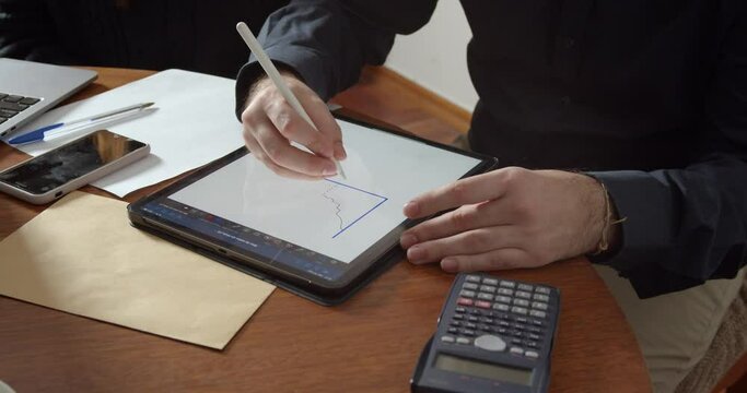 Man's hands making a sketch of a economy graph