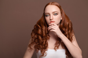 Redhead beauty. Young woman with long ginger hair and healthy clean skin portrait