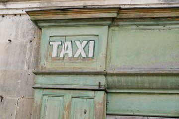 old vintage taxi sign on wooden office agency of cab driver