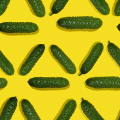 Green young cucumbers with shadow on yellow background, top view, food color seamless pattern, square.