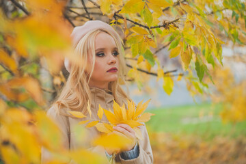 Naklejka na ściany i meble Beautiful Autumn Woman with yellow autumn leaves on fall nature background