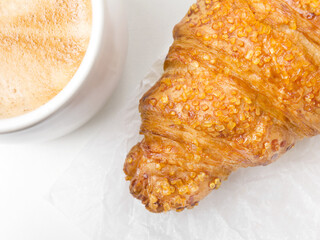 pastry croissant on white paper background with cup of coffee. French food