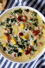 Homemade Zuppa Toscana with Kale and Bread in a white bowl, top view. Flat lay, overhead, from above.