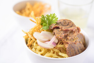 Northern Thai food (Khao soi), Spicy coconut milk curry egg noodles soup with beef in a bowl