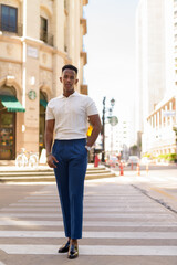 Full length shot of young African businessman outdoors walking over crosswalk