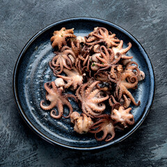 Grilled seafood variety with vegetables on dark background.