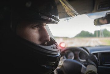 Rally driver concept. Man in the helmet drives a car.