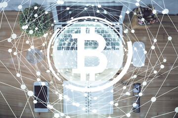 Blockchain theme hologram drawings over computer on the desktop background. Top view. Double exposure.