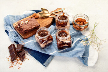 Trifles made with chocholate mousse and brownie on light gray background.
