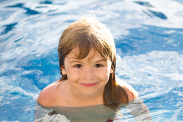 Happy boy playing and in swimming pool or sea water. Funny kids summer face.