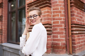 student with a book near the Institute on the street and glasses on her face