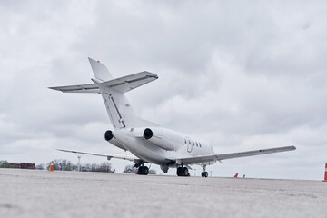 White plane. Turboprop aircraft parked on the runway at daytime