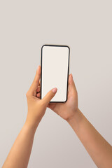 Closeup shot of a woman typing on mobile phone isolated on white background.. Girl's hand holding a modern smartphone and pointing with figer. Blank screen