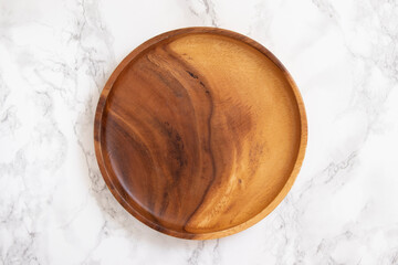 Natural wood plate on marble table