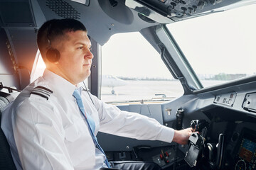 Side view. Pilot in formal wear sits in the cockpit and controls airplane