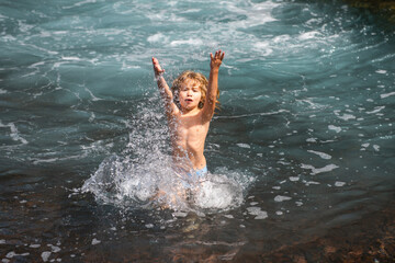 Happy child playing in the sea. Kid having fun at the beach. Summer vacation and active lifestyle concept.
