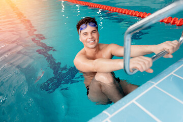 Young positive happy male swimmer in blue water swimming pool after race, top view