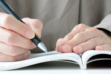 テキストブックに書き込む人物の手元