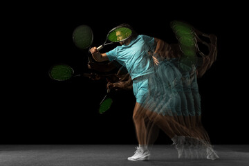 Young Caucasian man, professional tennis player isolated on black background in mixed neon light....