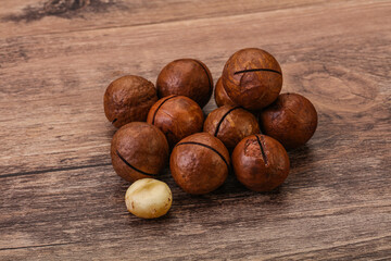 Brown macadamia nut heap over background