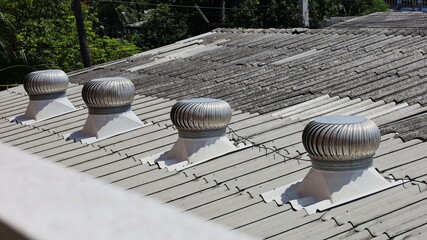 Four metal turbine ventilators on the roof. Ventilation system on tile roof for indoor heat control. Selective focus © kanin