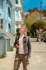 A young man walks the streets admiring the townhouses with famous Victorian architecture, San Francisco