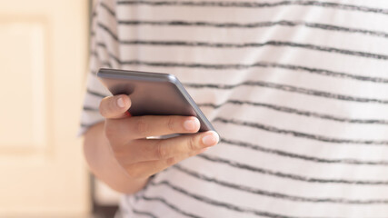 Hand holding and using smartphone.