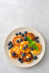Cottage Cheese Pancake with blueberries and mint in a plate on a gray background