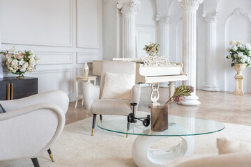 rich luxurious interior of a cozy room with modern stylish furniture nd grand piano, decorated with baroque columns and stucco on the walls