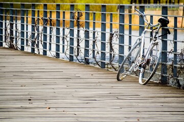 Old white rusty bicycle park at the wooden pier.