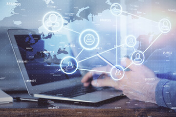 Double exposure of man's hands holding and using a phone and social network theme drawing.