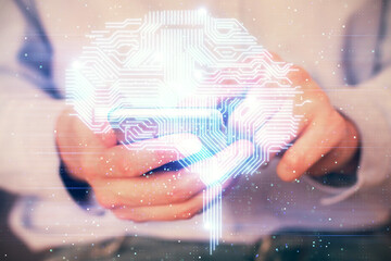 Double exposure of man's hand holding and using a digital device and brain hologram drawing. Data concept.
