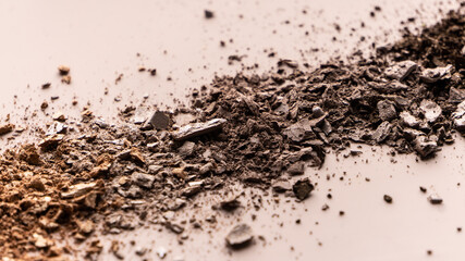 broken eye shadow scattered across the smooth pink surface. Texture background, advertising the structure of cosmetics. macro, copyspace