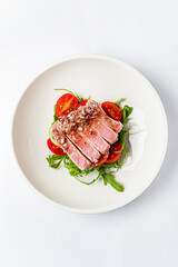 tuna fillet with salad on white plate