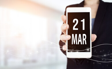 March 21st . Day 21 of month, Calendar date. White smartphone with Calendar date in businesswoman...