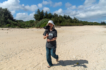 徳之島の伊仙町の喜念浜で動画撮影をする女性フォトグラファー