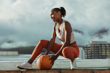 Fitness woman crouching with medicine ball