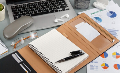 Opened agenda near laptop and modern gadgets on a grey close up