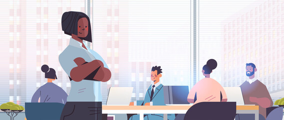 businesswoman standing in front of mix race businesspeople coworkers discussing during conference meeting