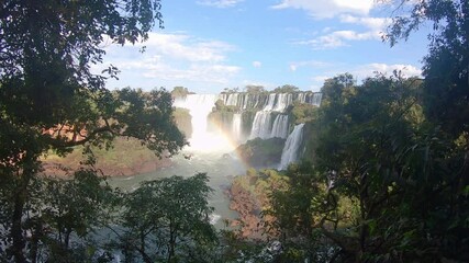 A rainbow in Iguazu Falls, Misiones, Argentina, wide backward shot. Iguazu Falls Waterfall in South America, 7 wonders of the world in Argentina province of Misiones and the Brazilian state.
