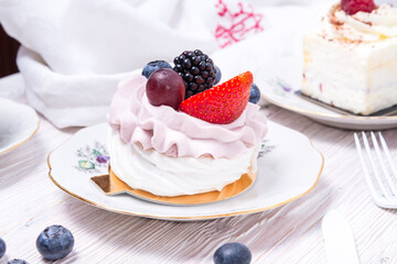 Piece of berry cake decorated with fresh berries on wooden background