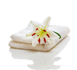 White spa towels with lily on white and reflection